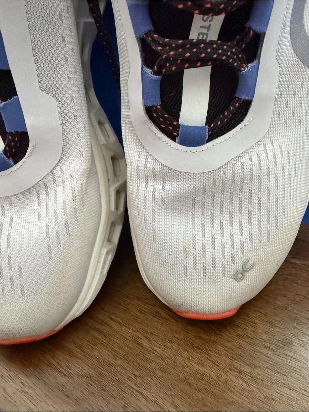 On Running Gray Sneakers with Blue Accents and Black/Orange Laces